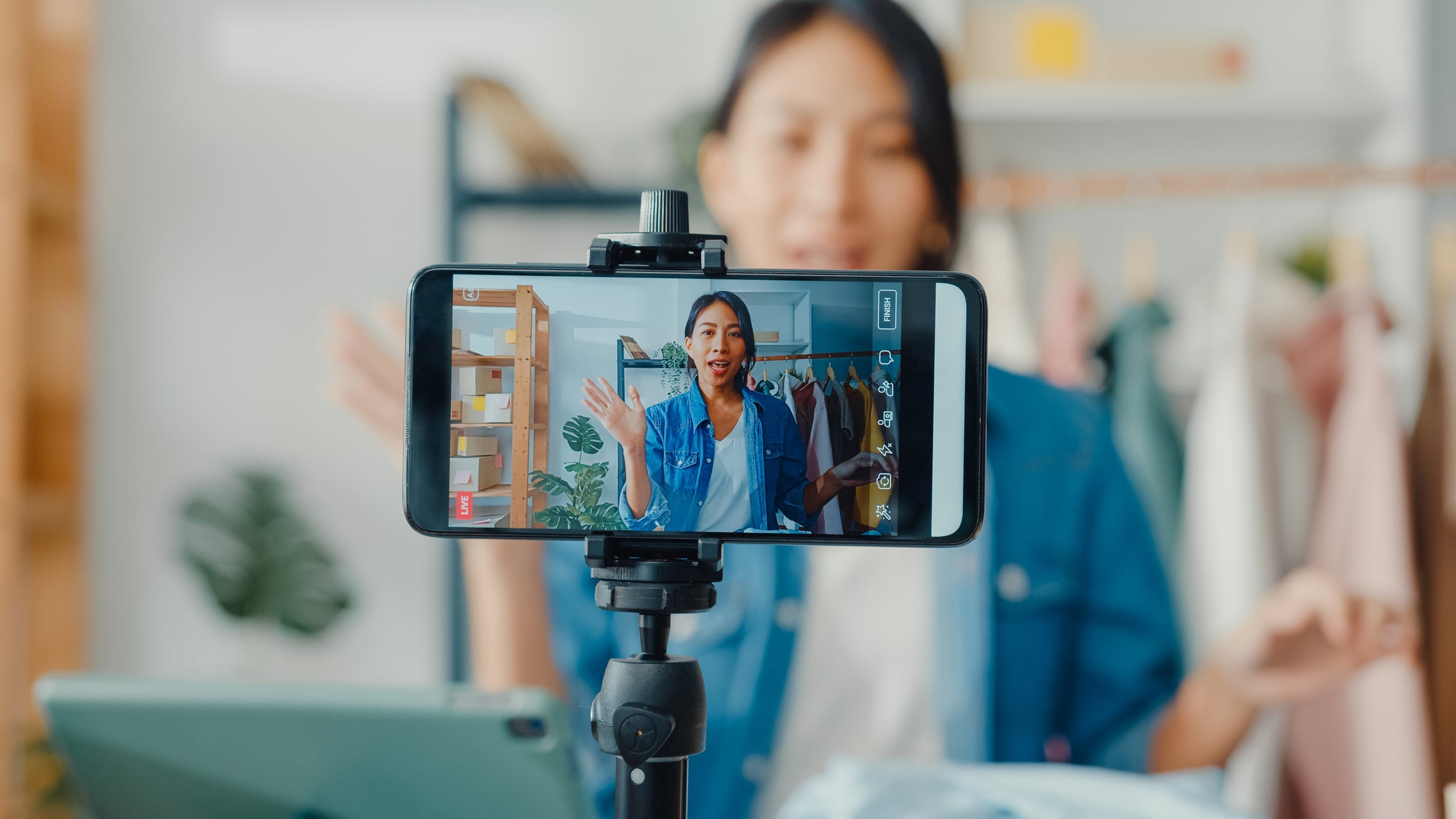 A shop owner recording a video on her phone