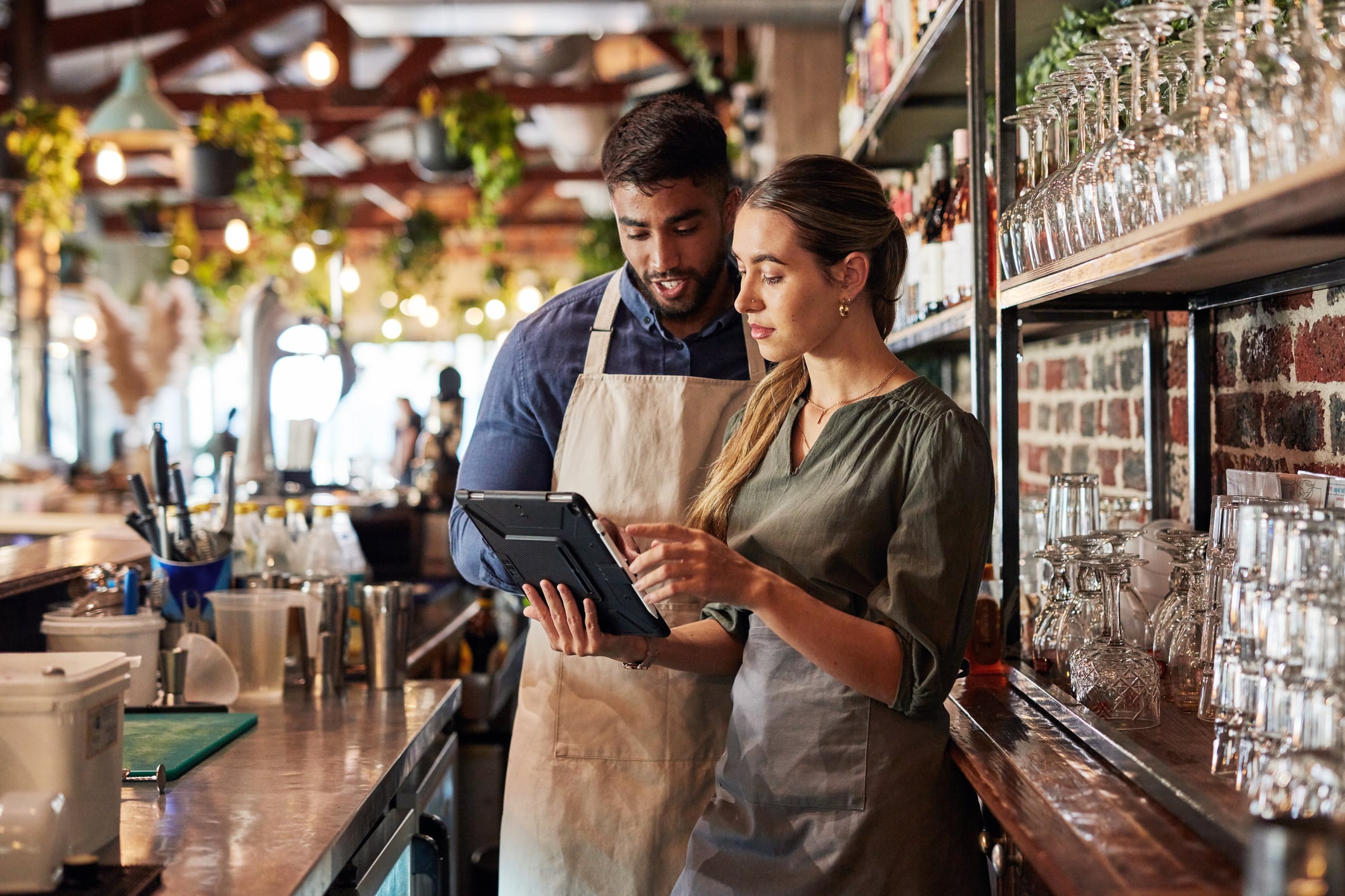 Two small business owners reviewing their books behind the bar
